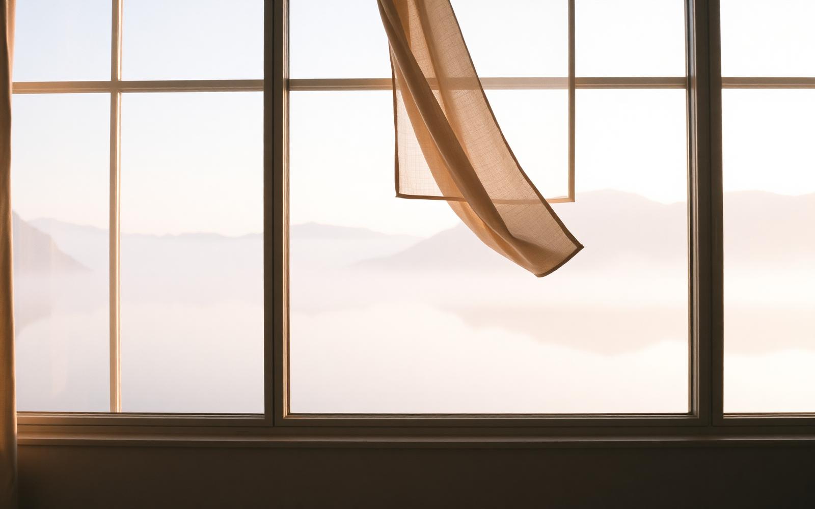 Morning light and distant hills seen through a wide window